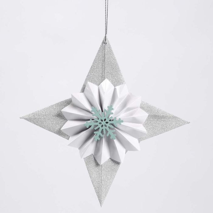 Une étoile en papier pailleté décorée avec une rosette et un flocon de neige