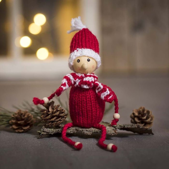 Un lutin tricoté en fil acrylique, avec des perles en bois pour les mains et les pieds.