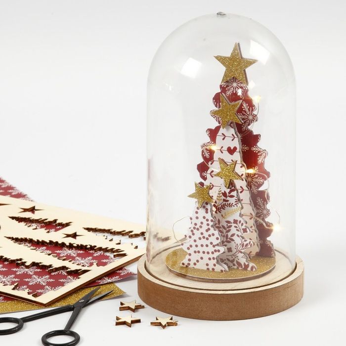 Une cloche en verre décorée avec des figurines assemblées en bois