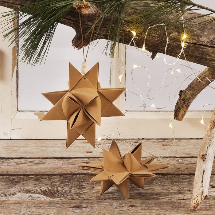 Une étoile de Noël tissée à partir de bandes en simili-cuir, avec un cordon en cuir et des perles en bois pour la suspension