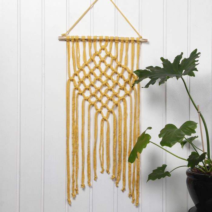 Une tenture murale tressée en macramé avec du fil tubulaire en coton