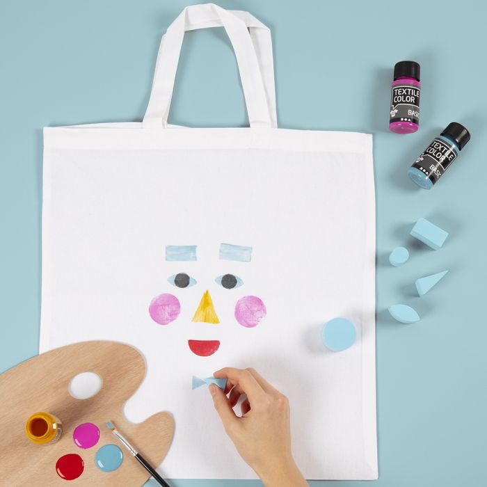 Un sac de courses décoré d’un motif de visage imprimé au tampon