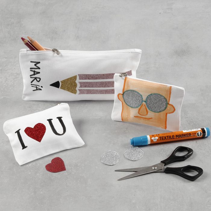 Une trousse et un porte-monnaie décorés avec du film thermocollant et des marqueurs pour textile
