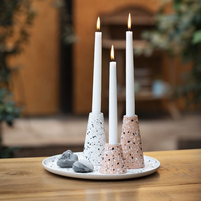 Un plat et des bougeoirs en fibres de bambou décorés avec des éclats de terrazzo