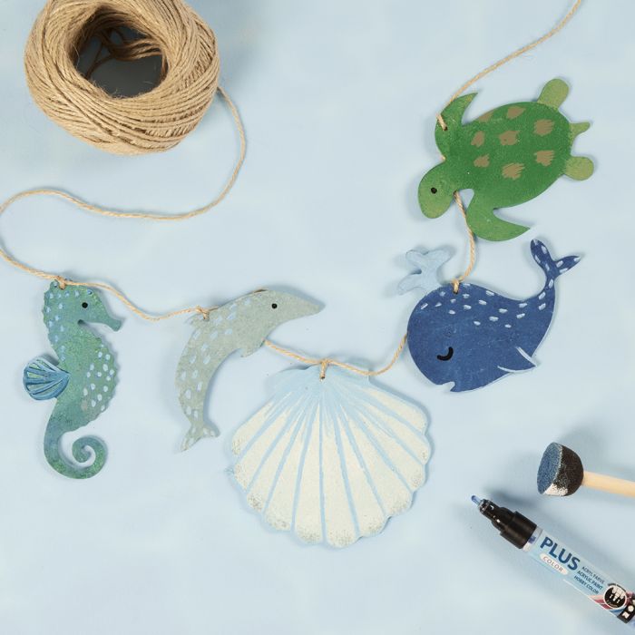 Une guirlande avec des créatures marines en bois décorées avec de la peinture artisanale.