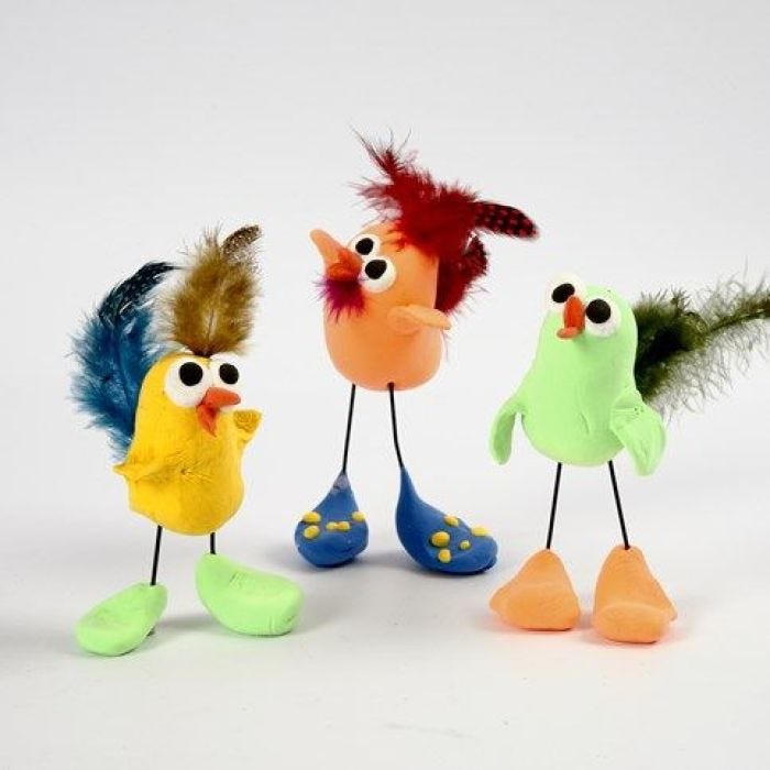 Une poule en pâte Silk Clay sur des pattes en fil de fer et décorée de plumes