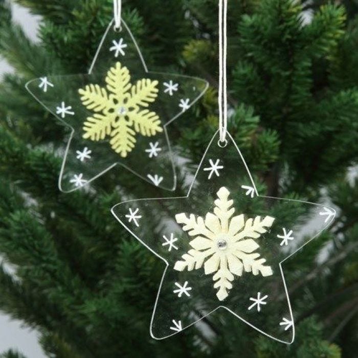 Des étoiles en acrylique, décorées de flocons de feutre et de dessins