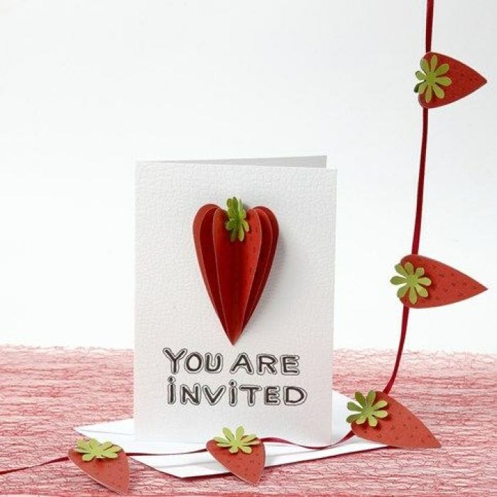 Une invitation décorée de fraises faites à partir de papier martelé