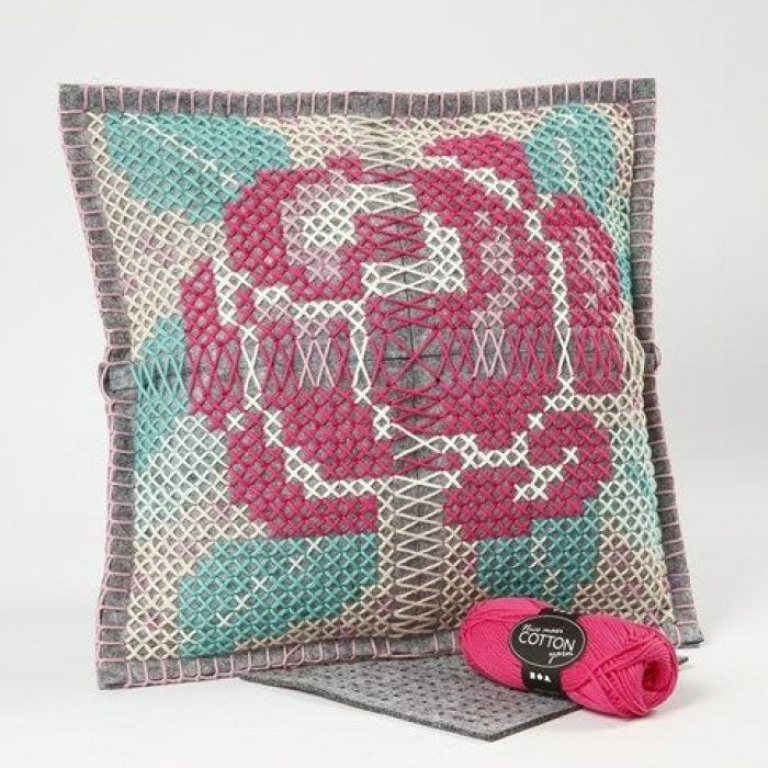 Un coussin décoré d'une rose brodé