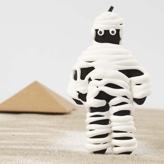 Une momie faite à partir d'une poupée en tissu peinte en noir enroulée dans de la pâte Silk Clay