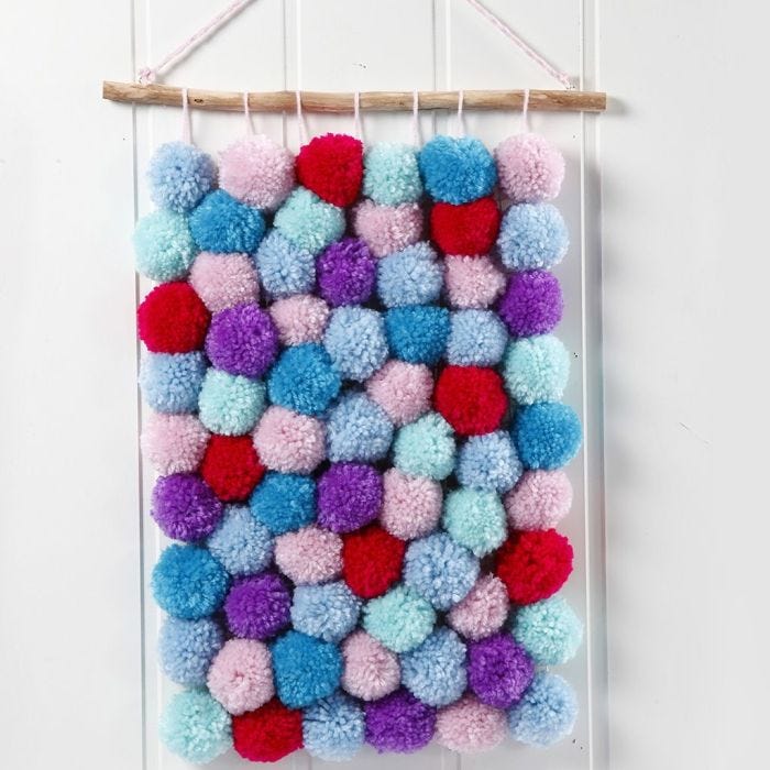 Une décoration murale avec des pompons