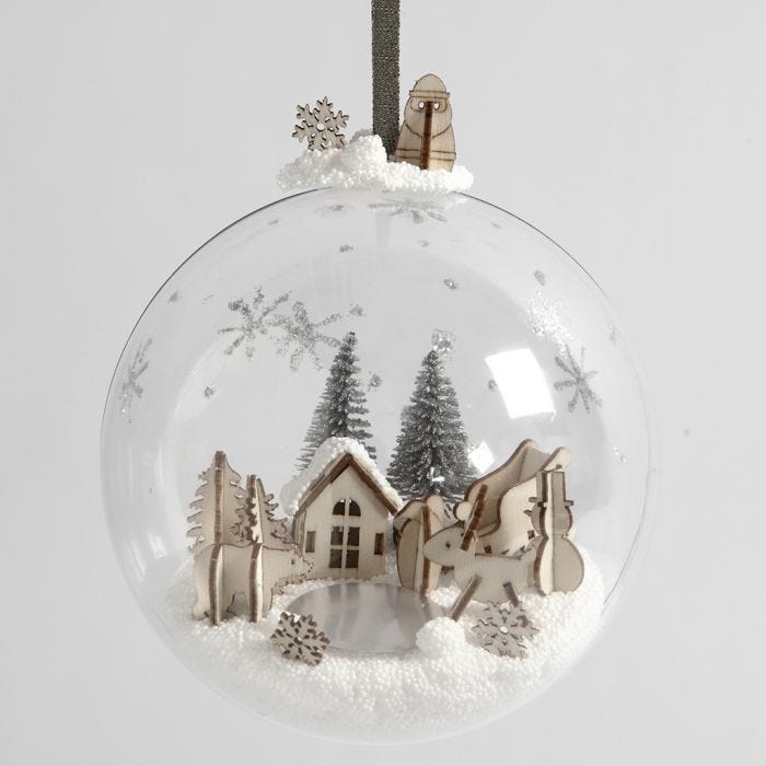 Un monde miniature en pâte Foam Clay et des figurines en bois à l'intérieur d'une boule de Noël