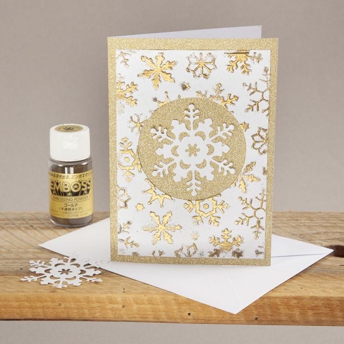 A Christmas Card decorated with an embossed Design and a punched-out Snowflake