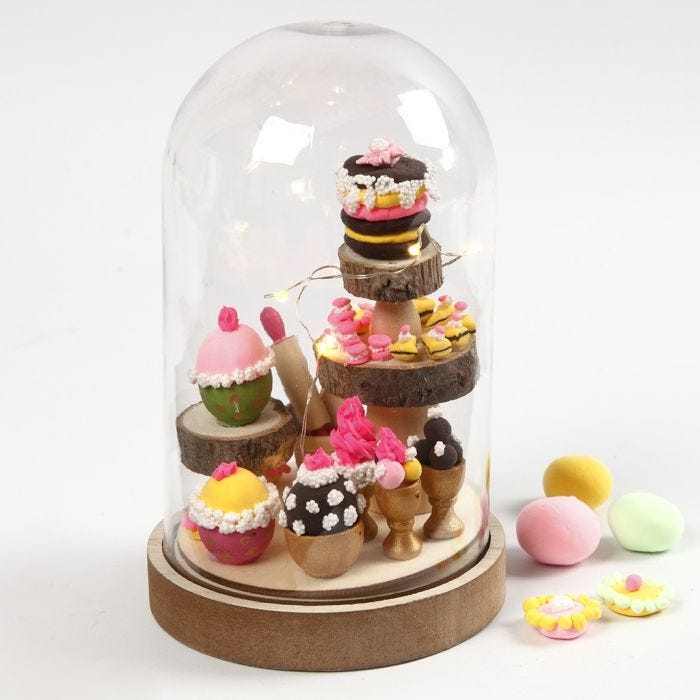 Une cloche transparente avec des gâteaux miniatures à l'intérieur