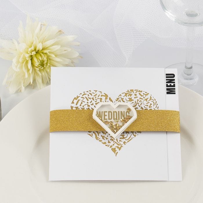 Un menu de mariage fait avec du papier design doré à paillette et un autocollant à secouer