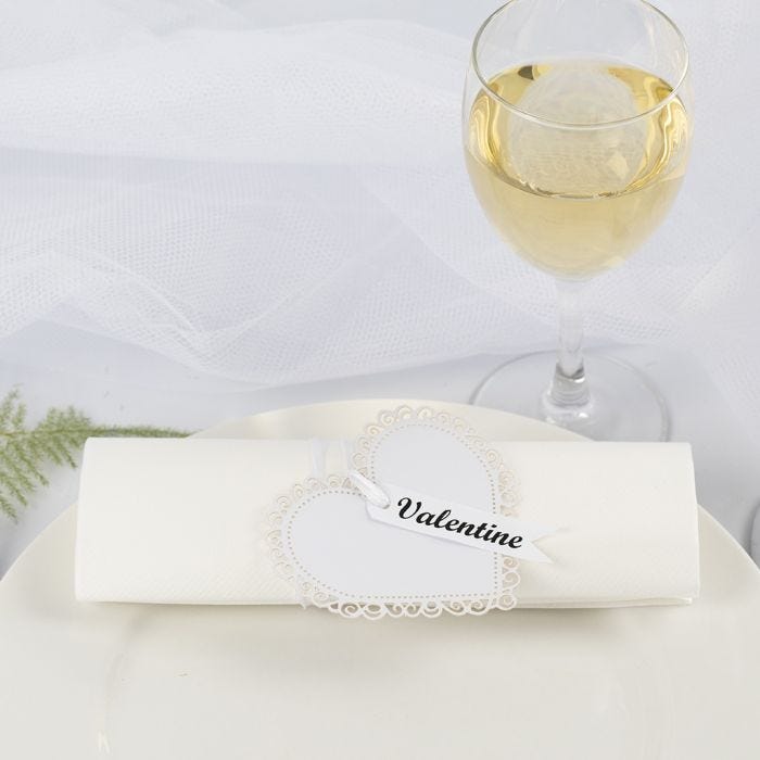 Un rond de serviette / marque-place de mariage fait à partir d'un coeur en papier cartonné et un ruban de satin