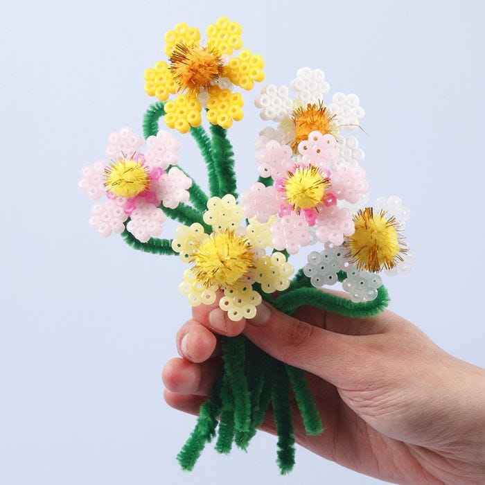 Des fleurs faites avec des perles à repasser Nabbi, des fils chenille et des pompons