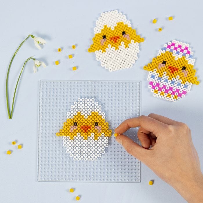 Des poussins de Pâques faits avec des perles à repasser Nabbi sur une plaque à picots