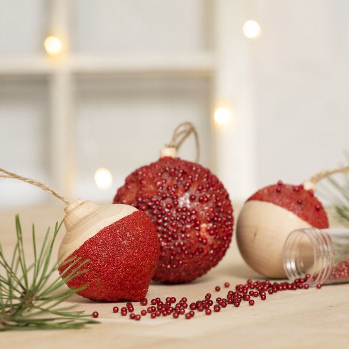 Boules de Noël décorées avec de la peinture acrylique, de la base collante transparente, du gel de modelage autodurcissant et de mini perles de verre