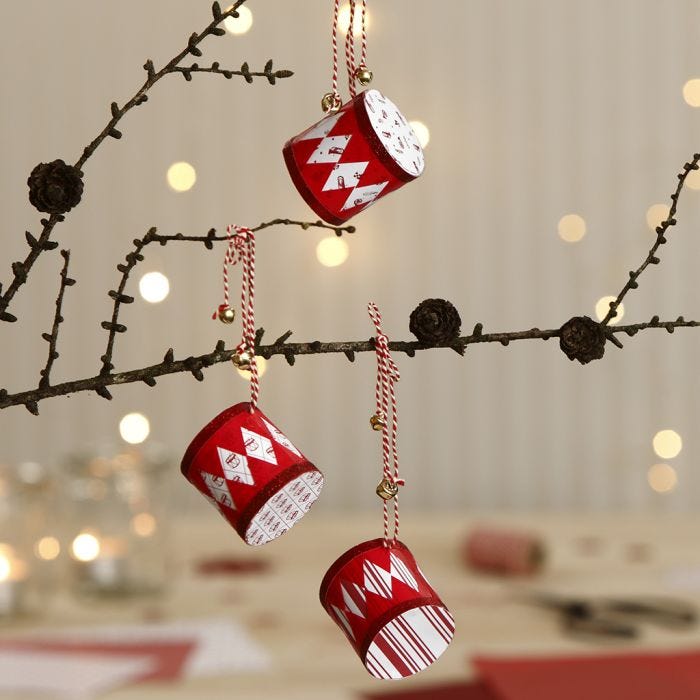 Des tambours de Noël faits avec du papier à motif et décorés de cloches