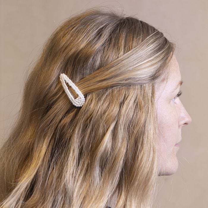 Une barrette à cheveux décorée avec des perles de cire cousues ensemble