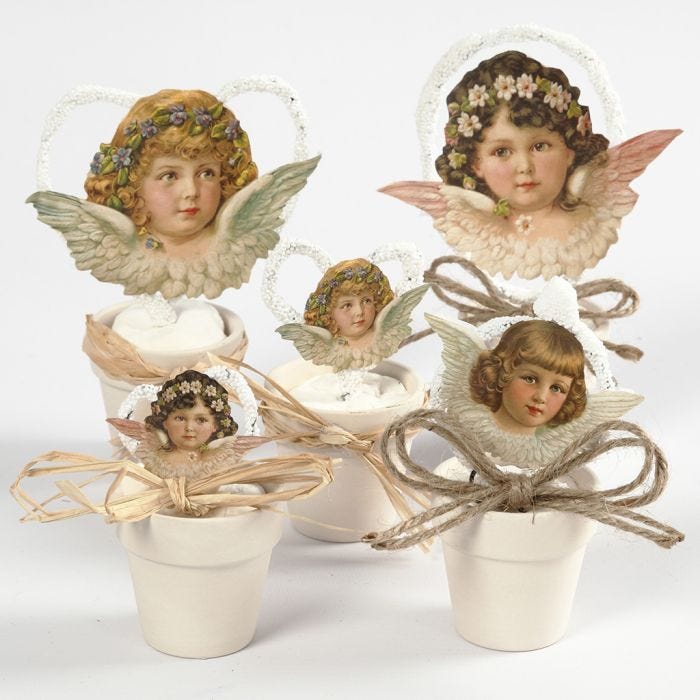 Des découpes d'anges vintage dans des petits pots de fleurs