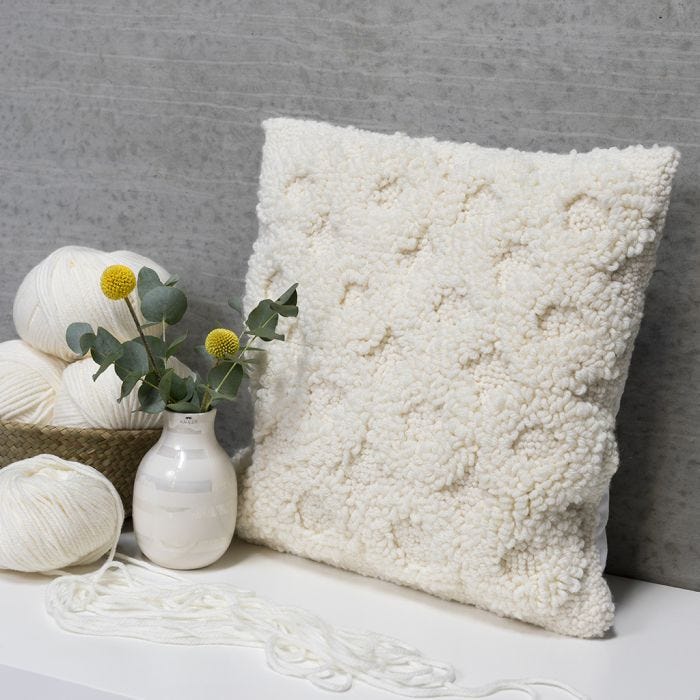 Un coussin décoré d'un motif brodé au poinçon