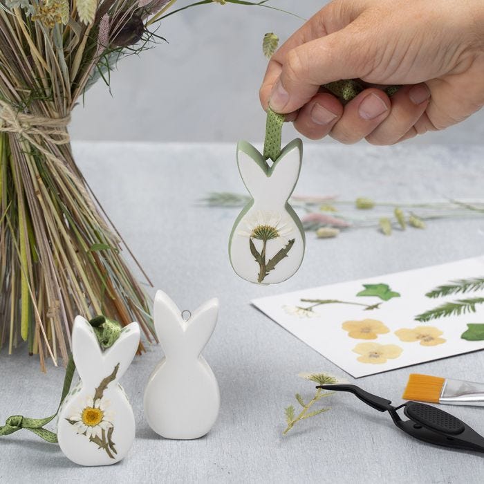 Des décorations de Pâques en porcelaine à suspendre, décorées de fleurs séchées