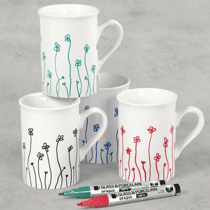 Des tasses en porcelaine décorées de fleurs dessinées aux feutres pour verre et porcelaine