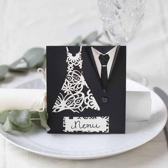 Un menu de mariage décoré avec une robe et un smoking