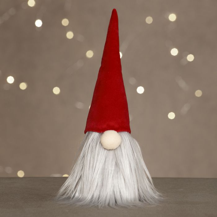 Un lutin curieux avec une longue barbe et un chapeau de lutin en velours