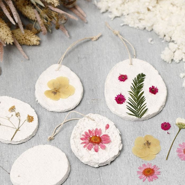 Hanging decorations from papier-mâché pulp decorated with dried flowers