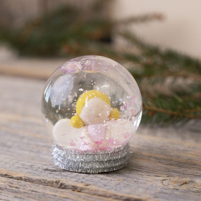 Une boule à neige avec un ange fait en pâte Fimo