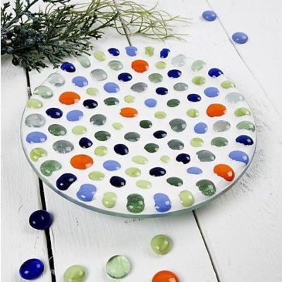 Un plat en verre avec une décoration en mosaïque.