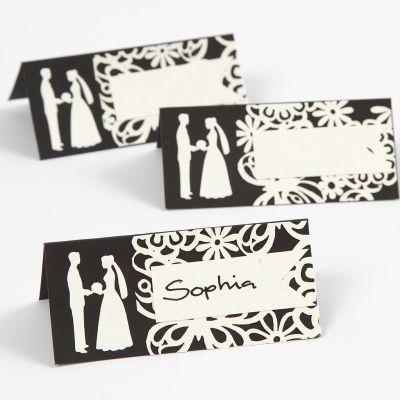 A place card with a punched-out wedding design and laced card