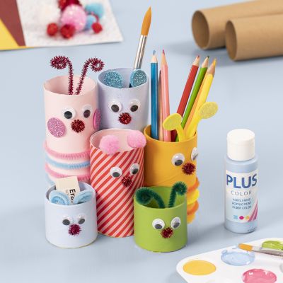 Un porte-crayons en tubes de carton décoré avec de la peinture pour loisirs créatifs et des matériaux de bricolage de base.