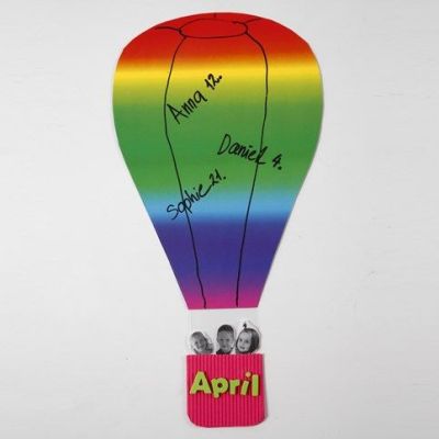 Une montgolfière faite de papier cartonné arc-en-ciel et d'un panier en carton ondulé