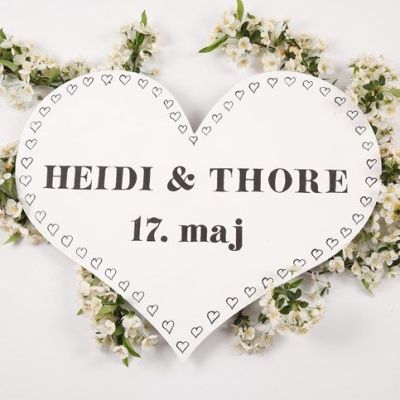 Un cœur en bois peint et décoré comme un panneau pour une arche de célébration