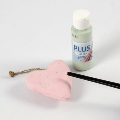 Des formes textiles décorées de points de peinture et d'un bouton design cousu