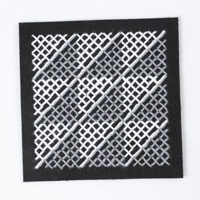 Un coussin avec le dessin d'une croix et un  motif au tricot