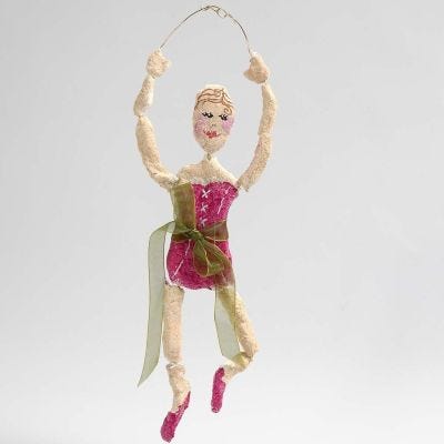 Une ballerine faite de fil de bonsaï doré recouvert de pâte à papier mâché.