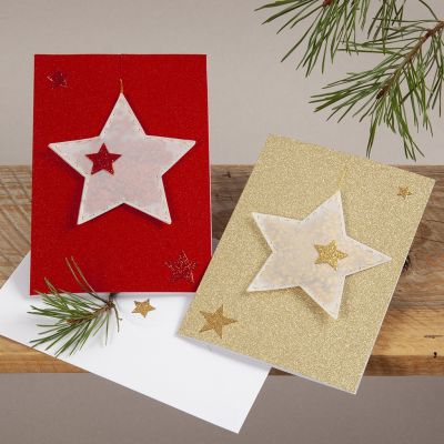 Cartes de Noël pailletées avec des étoiles en papier calque suspendues.