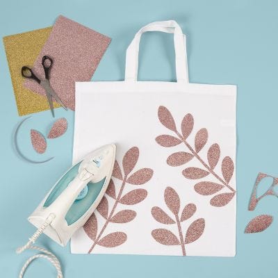 Un sac à provisions décoré de motifs de branches d'épinette en film à repasser