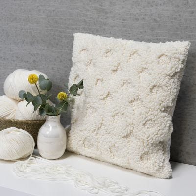 Un coussin décoré d'un motif brodé au poinçon
