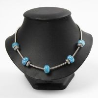 Un collier articulé avec des perles en verre et en métal