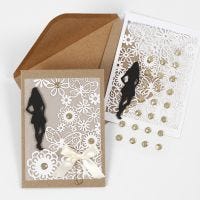 Une invitation avec une silhouette en papier cartonné, du papier cartonné au motif de dentelle et du papier vélin pour une première communion