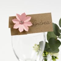 Un marque-place décoré avec une fleur en papier cartonné effet 3D