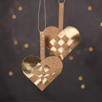 Des paniers de Noël tressés en forme de coeur confectionnés avec du papier imitation cuir naturel et doré