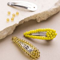 Une barette à cheveux décorée avec des perles de rocaille et des perles de verre