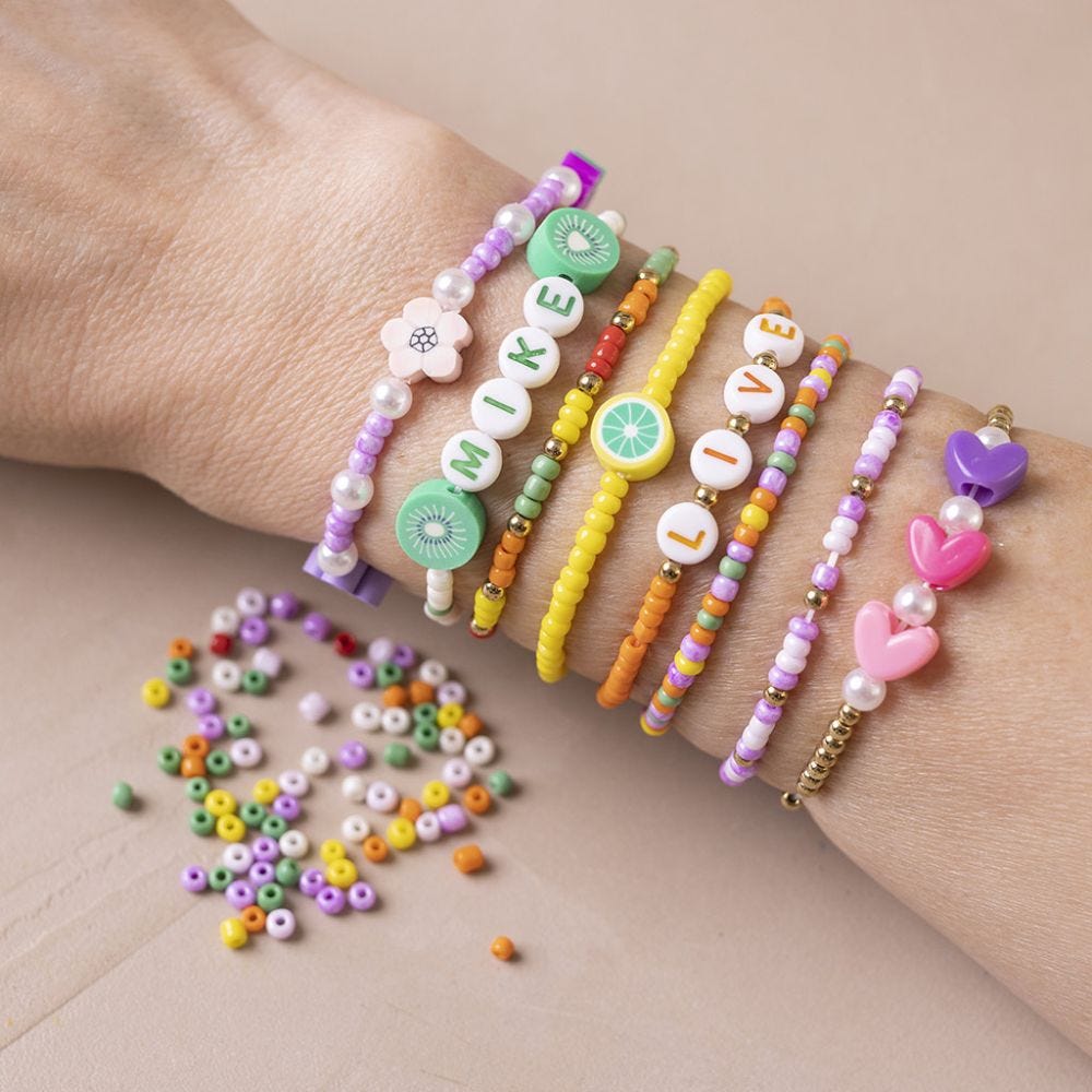 Un bracelet avec des perles de rocaille, des perles en forme de lettres et perles en bois de différentes formes